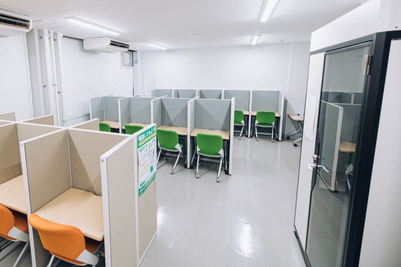 パーティションで仕切られた個別ブースが並ぶ、静かな学習または就職支援スペース