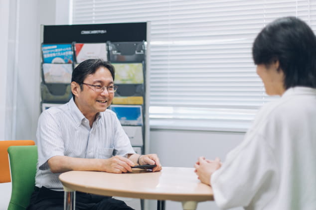 丸テーブルを挟んで教職員と学生が向かい合い、就職相談を行っている様子