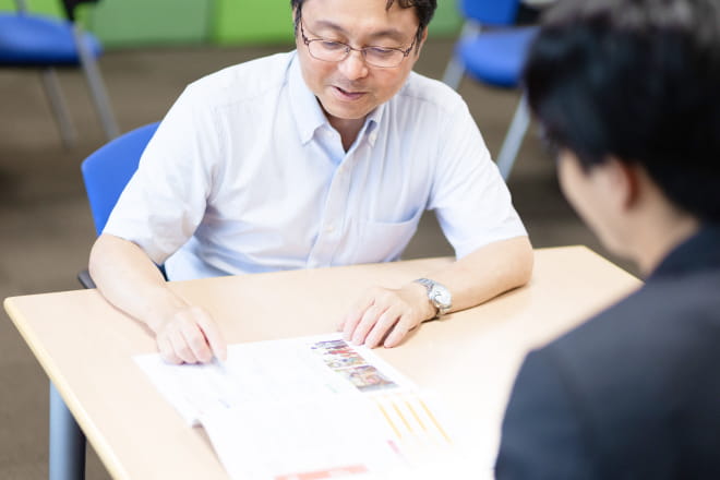 室内の明るい雰囲気の中で、穏やかな表情の対話が行われている
