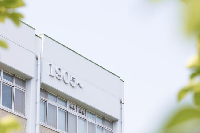 校舎の上部に「1905〜」と記された文字が見える大学の建物の一部