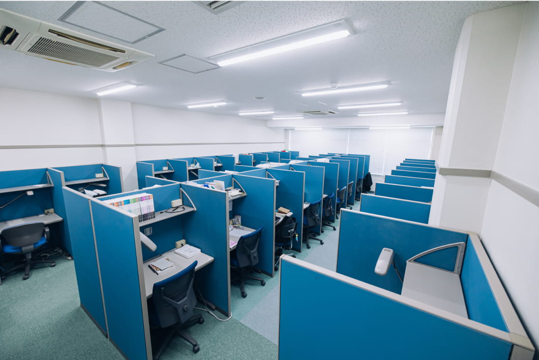 青いパーティションで仕切られた個別ブースが整然と並ぶ自習室や学習スペース