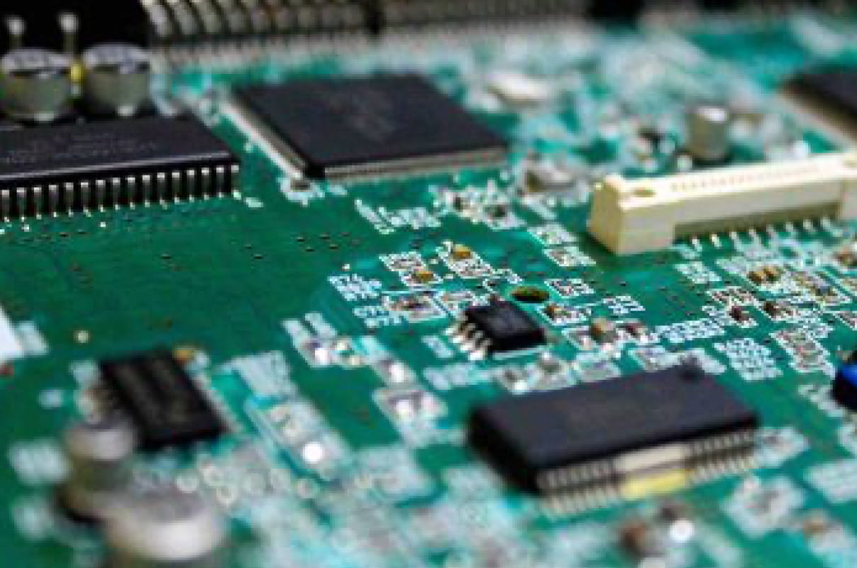 緑色のプリント基板に各種ICチップや電子部品が実装された、電子回路のクローズアップ画像